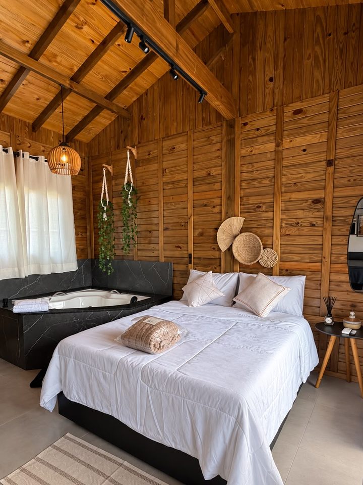 Estúdio 2: cama de casal com roupa branca e a banheira ao fundo