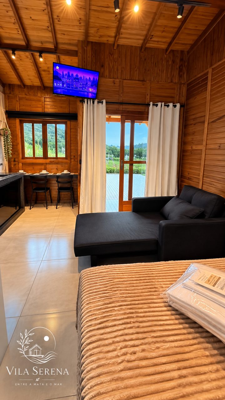 Estúdio 3: cama de casal, sofá e Smart TV no mesmo ambiente de madeira